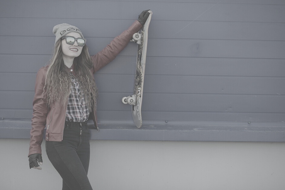 A Young Hipster Girl Is Riding a Skateboard. Girls Girlfriends F