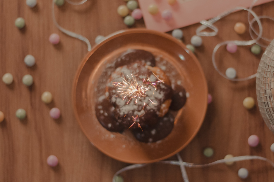 lighted sparkle candle on the cupcake with cofettis on the b